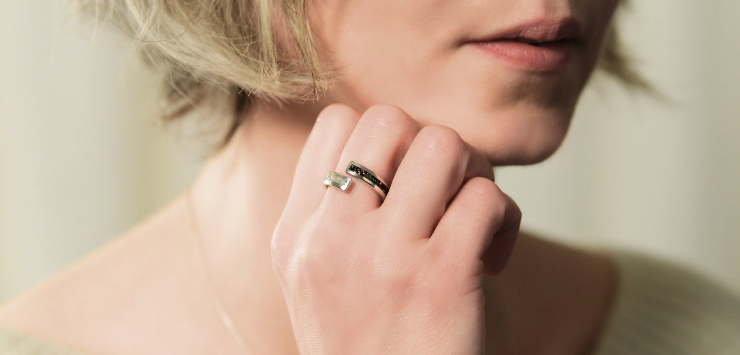 Opals & Ashes Dual Spiral Memorial Ring Silver. Modelled on female hand. Ashes blended with Black Fire and Pearl White Opals.