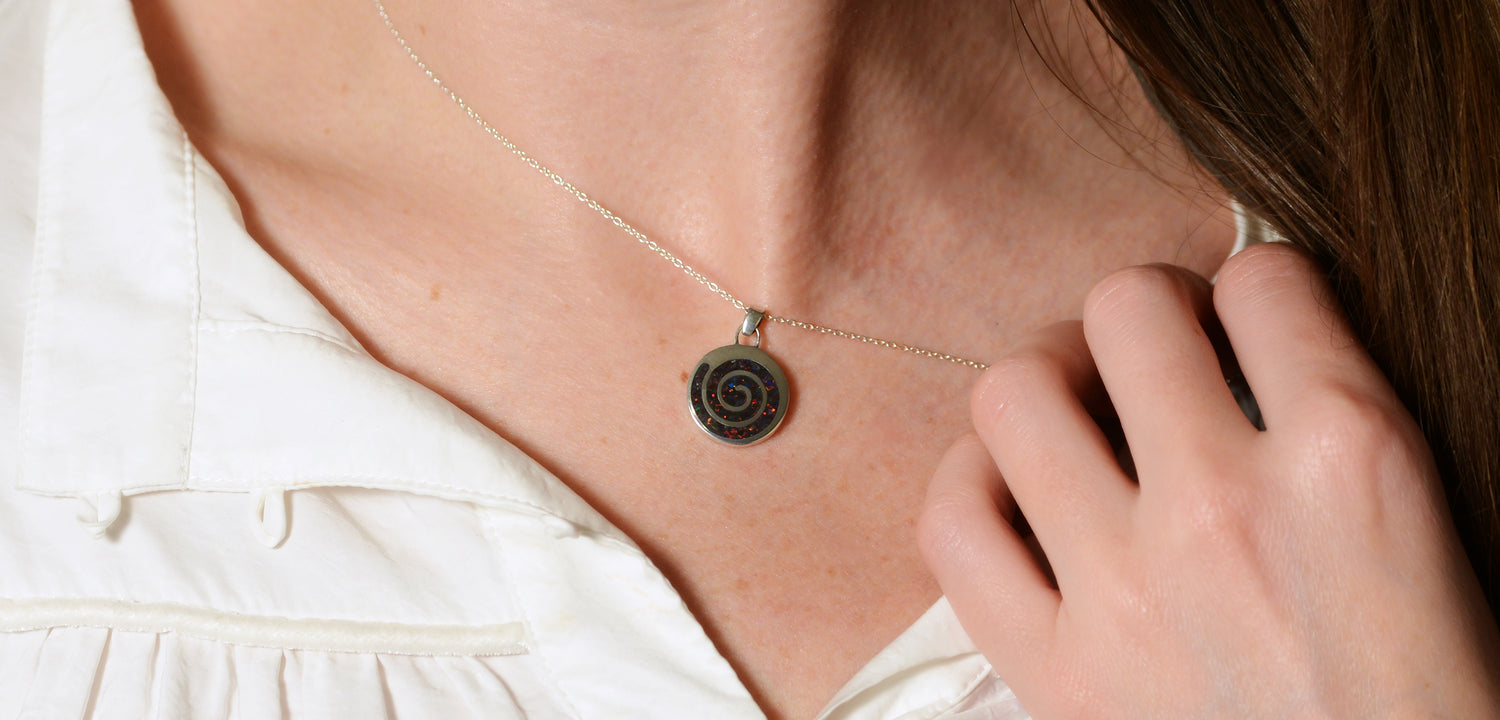 Opals & Ashes Spiral Memorial Pendant Silver. Modelled on female. Ashes blended with Black Fire Opals.