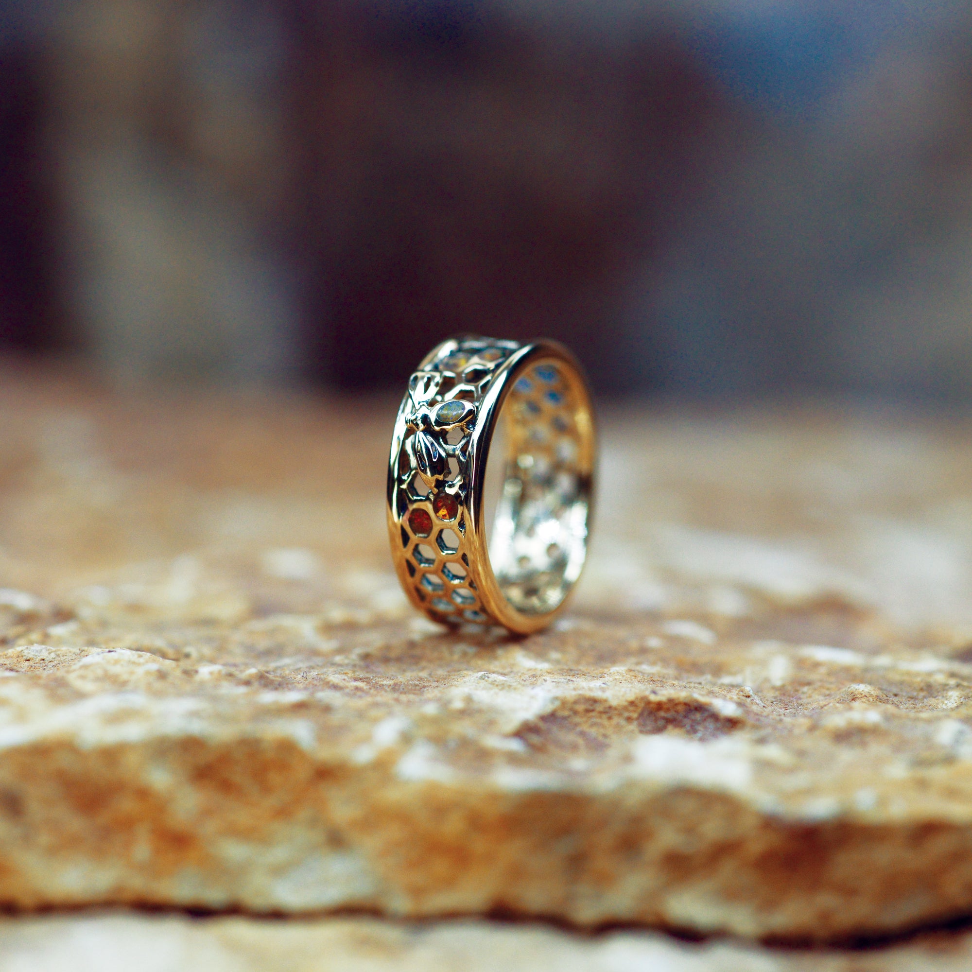 Opals & AShes Bespoke Hexagon Band with Honey Bee. Cast in 9ct Yellow Gold. Ashes were blended with Yellow Opals in four of the hexagons. The body of the Bee was filled with Pearl White Opals blended with ashes.