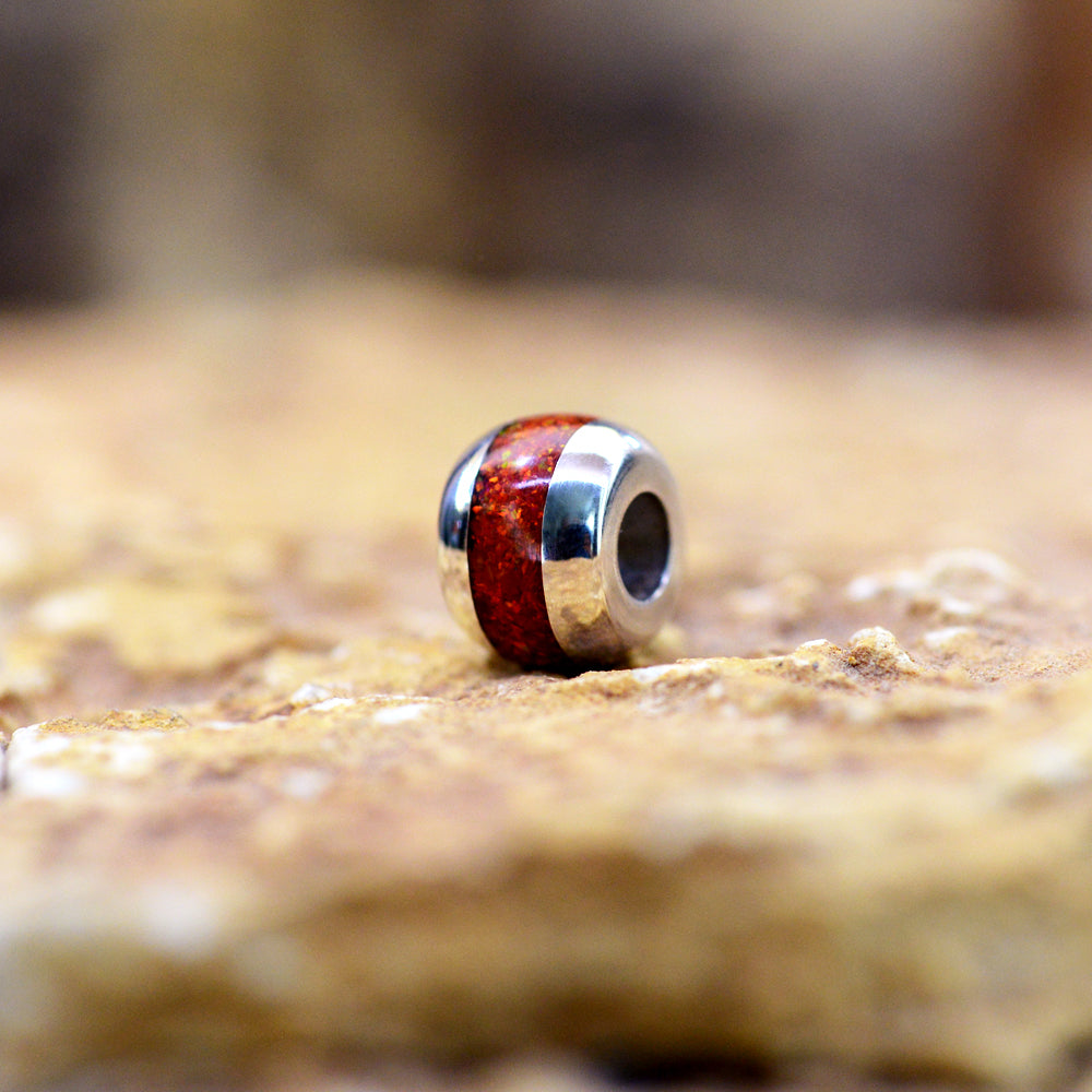Opals & Ashes Memorial Charm Sterling Silver. Ruby Red Inlay Photographed on rock close up