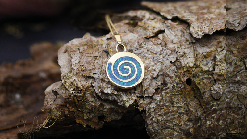 Spiral Ashes Pendant. Cast in 9ct Yellow Gold, Filled with pacific Blue opals blended with customers loved one’s ashes.