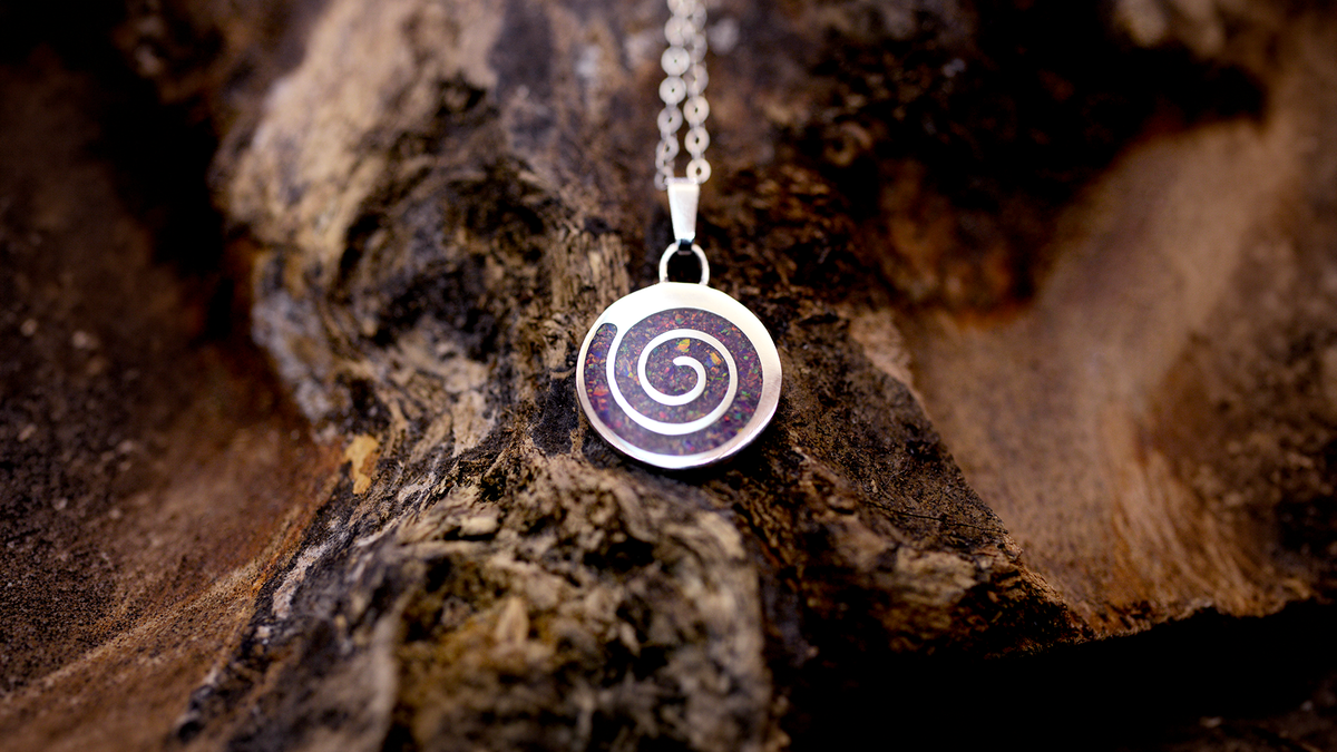 Spiral Ashes Pendant. Cast in sterling silver, filled with lavender opals blended with customers loved one’s ashes.
