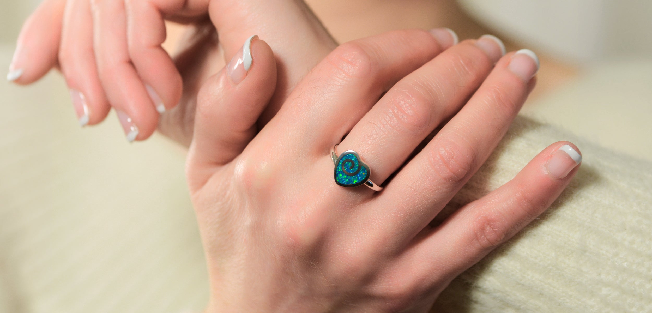 Opals & Ashes Angel Feather Memorial Ring Silver. Modelled on female hand. Ashes blended with Royal Blue Opals.